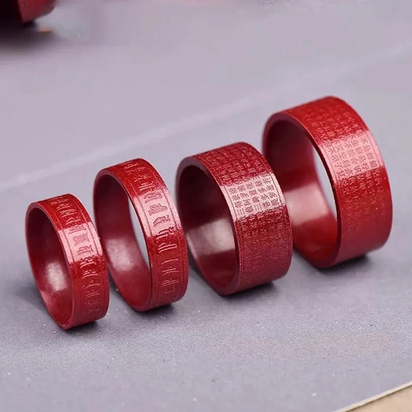 Cinnabar Buddhist ring detail shot showing precision laser engraving of sacred mantra on natural red stone