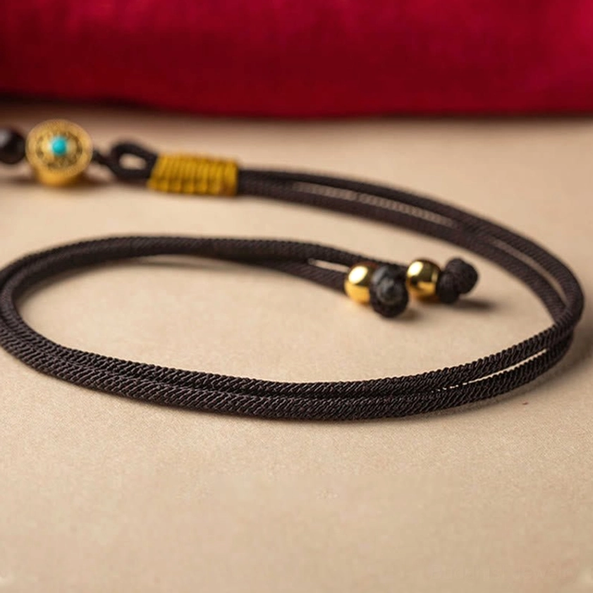 Cinnabar ruyi car hanging decoration showcasing natural maroon stone color variation and ornate gold pendant, artisan handcrafted piece
