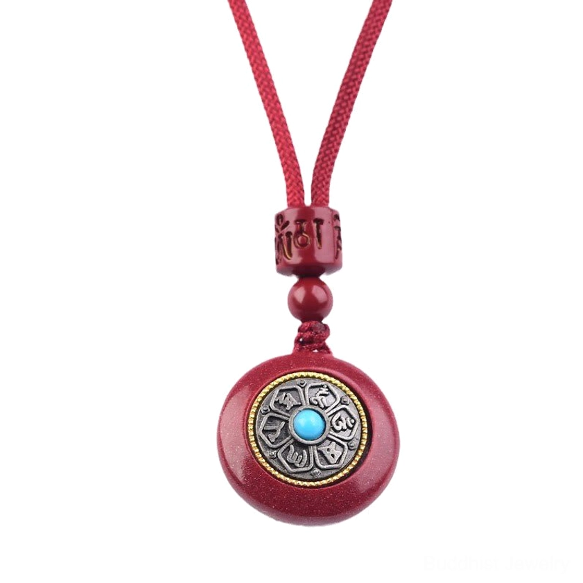 Cinnabar six-character mantra pendant with turquoise inlay and metal frame close-up detail shot
