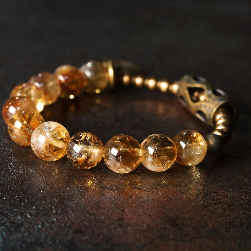 Golden citrine 10mm beads Buddhist bracelet with brass spiral charm and vintage metal spacer on dark background