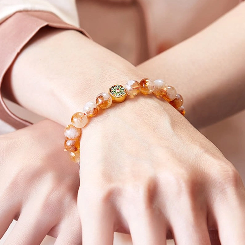 Woman wearing sterling silver citrine Om Mani Padme Hum protection bracelet on wrist with traditional Buddhist cuff