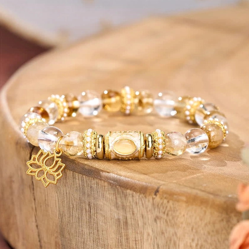 Close-up side view of citrine clear quartz beaded bracelet with gold barrel spacers and dangling lotus pendant