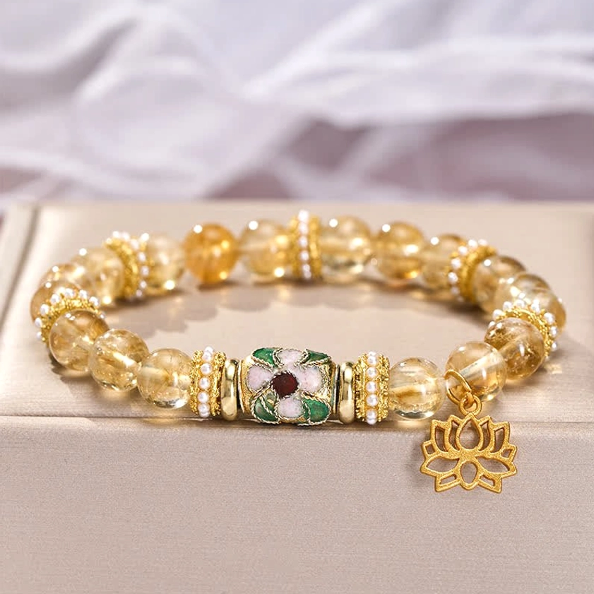 Citrine stone bracelet with gold spacers and hanging lotus charm on minimalist display tray - Buddhist prosperity bracelet