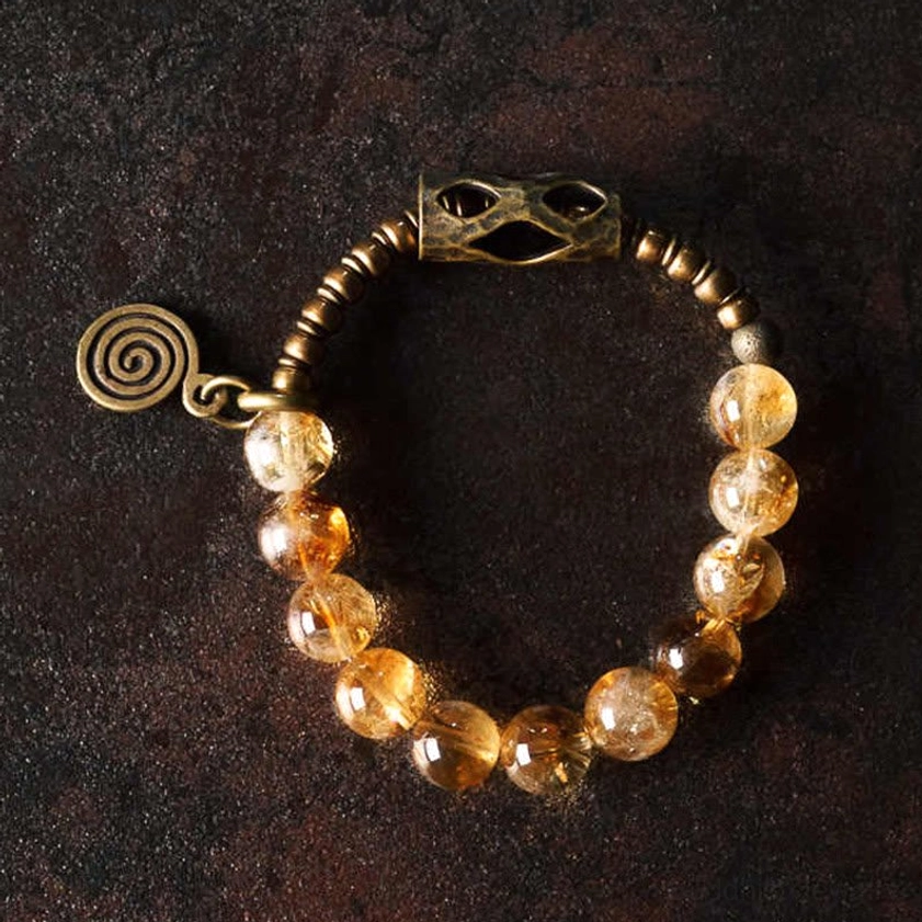 Natural citrine stone bracelet showing 10mm polished beads with spiral charm and metal clasp