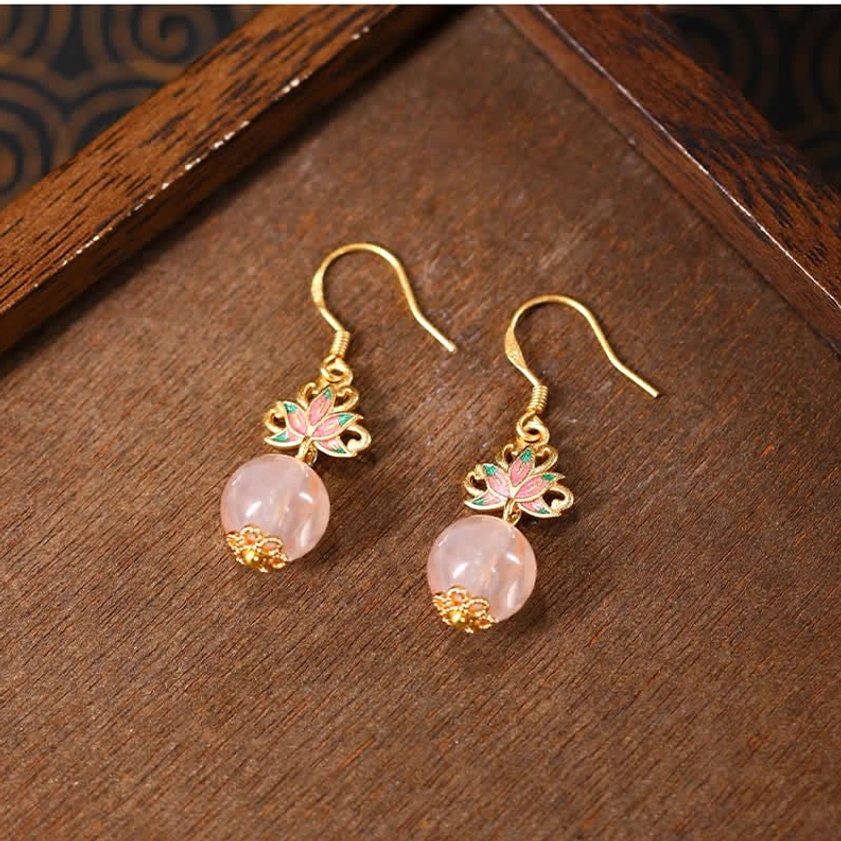 Handmade lotus enamel earrings featuring citrine crystals with cloisonné lotus charm and gold-plated hardware, angled top view