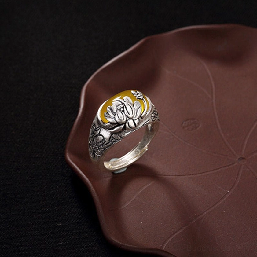 Left side view of citrine buddhist ring showcasing prominent lotus embossment and bright yellow oval gemstone on copper