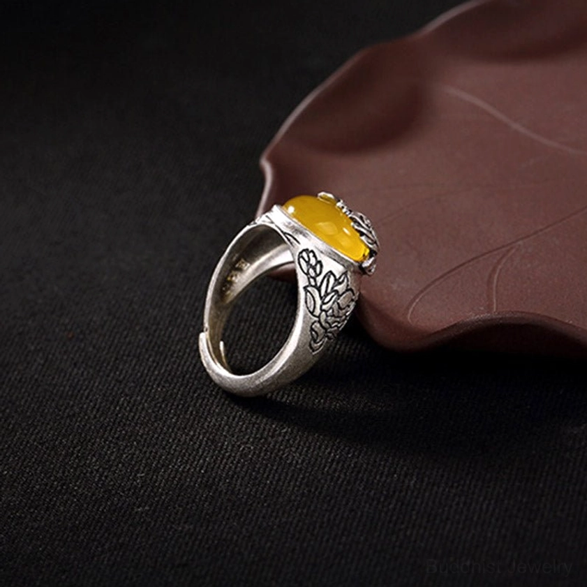 Right side perspective of handcrafted citrine ring with carved floral copper sides and oval yellow gemstone front setting