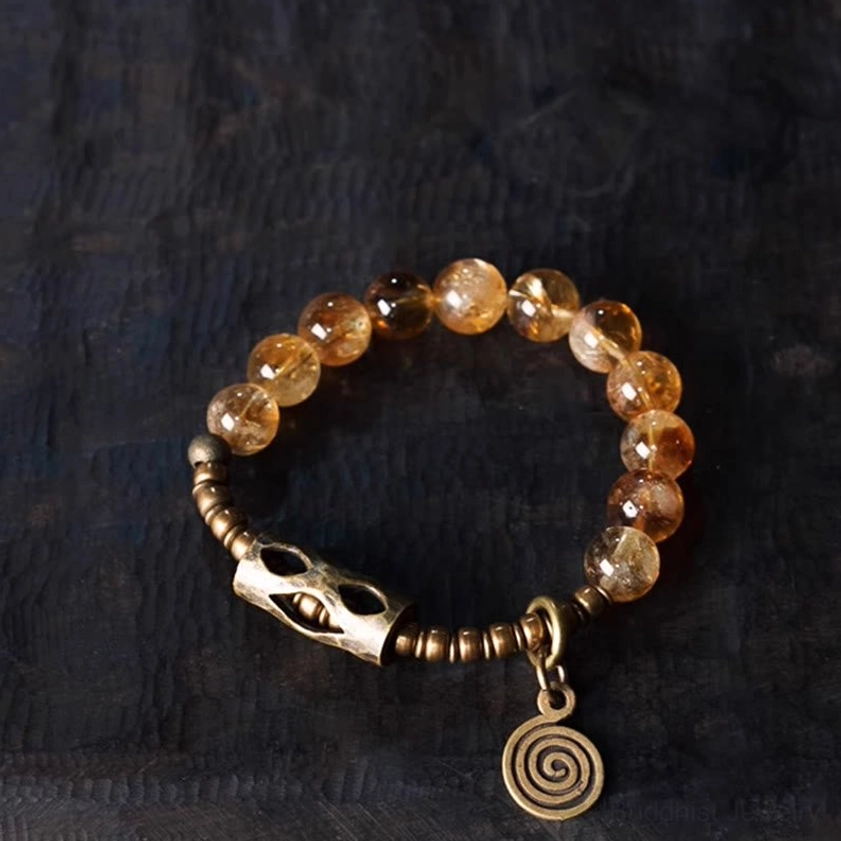 10mm citrine beads Buddhist protection bracelet flat lay with spiral pendant and metal accents