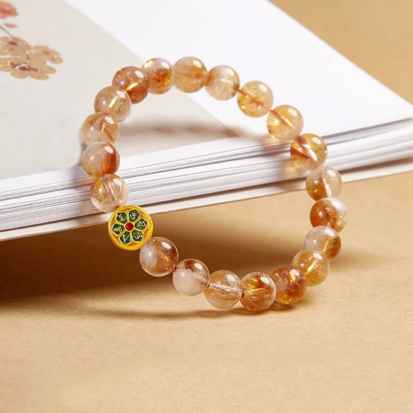 Handmade Buddhist protection bracelet showing natural citrine beads and sacred mantra charm detail