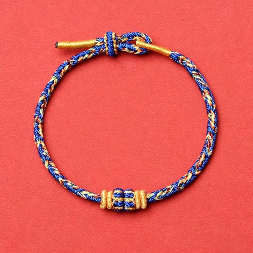 Classic blue and gold woven Buddhist bracelet with neat braid pattern and central decorative knot