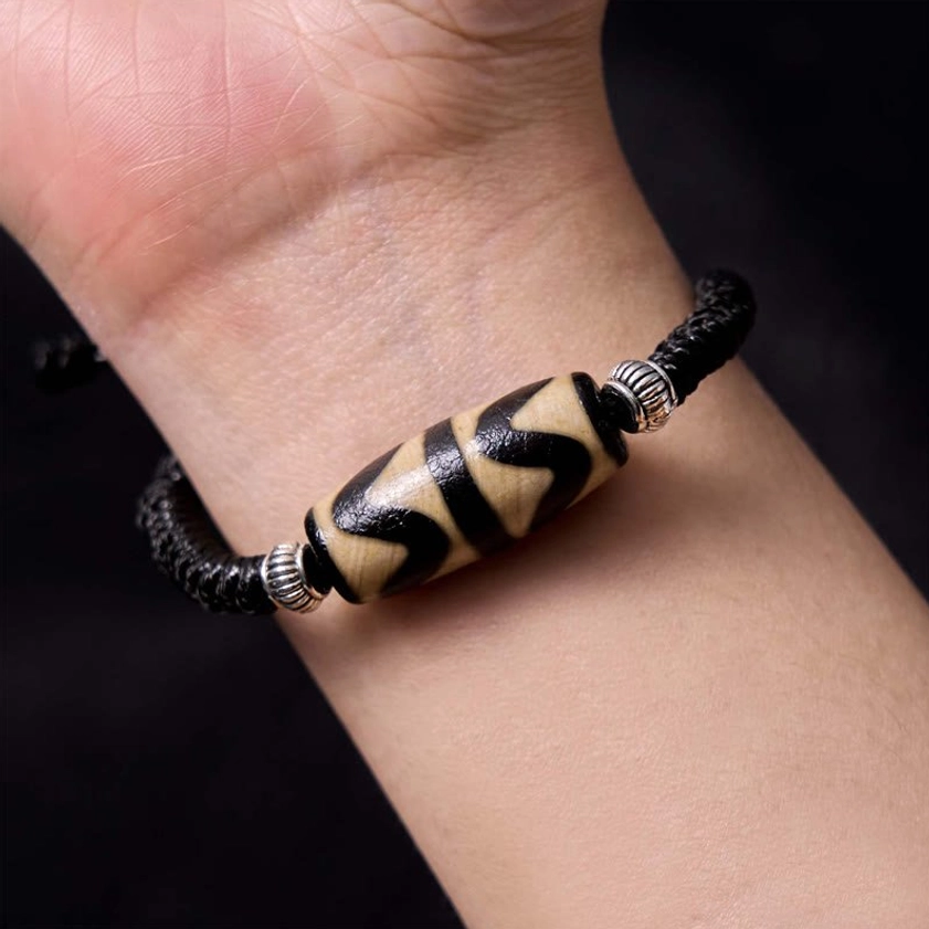 Classic dzi bead bracelet side angle detail displaying hand-painted motif and metal accents