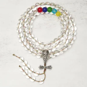 Clear quartz 108 bead mala with silver vajra charm pendant - top-down overhead view showing transparent round beads and colorful chakra accent beads
