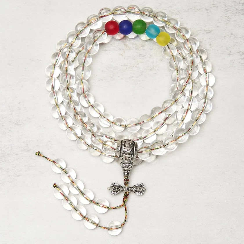 Clear quartz 108 bead mala with silver vajra charm pendant - top-down overhead view showing transparent round beads and colorful chakra accent beads