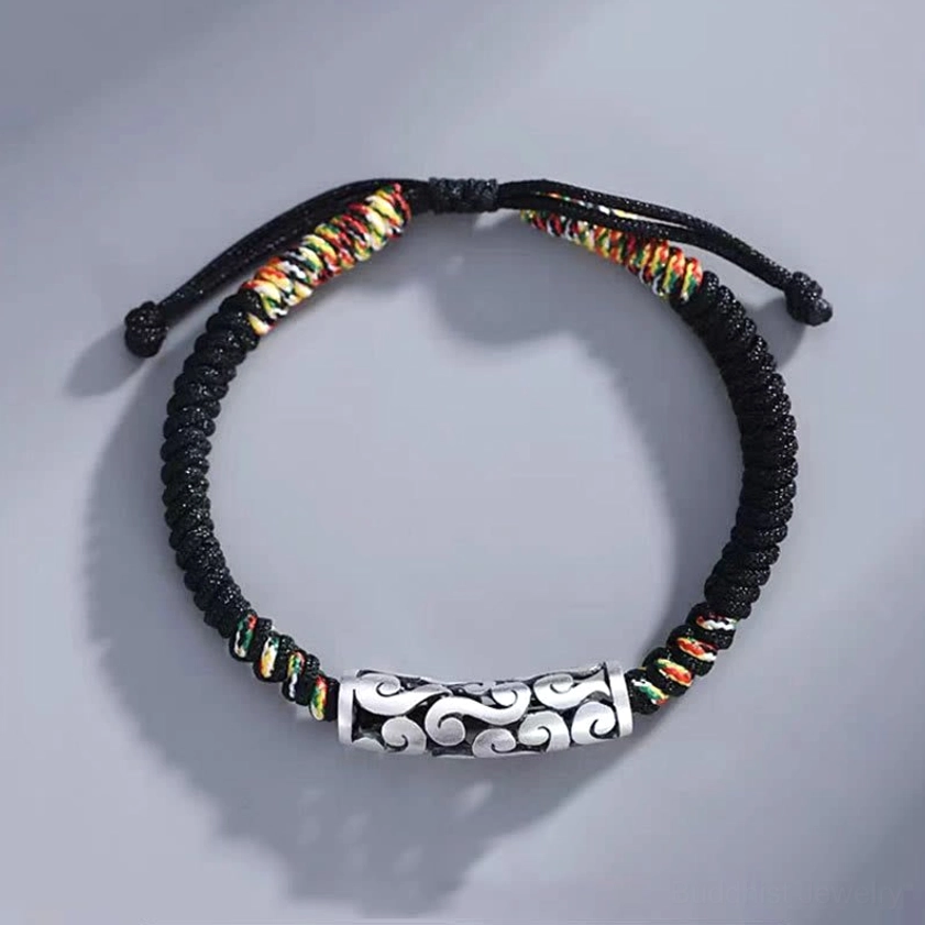 Cloud-patterned copper luck string bracelet flat lay overhead view with adjustable braided fasteners and detailed cloud engraving visible