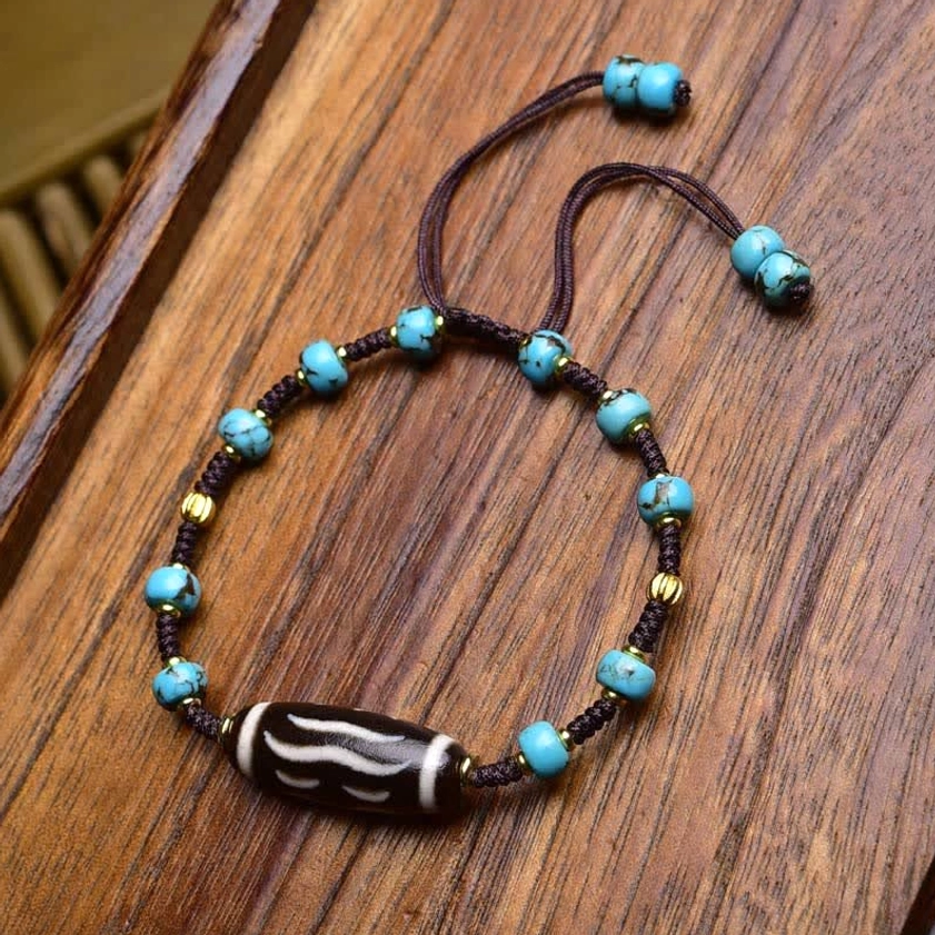 Coconut bead dzi bracelet with grey woven rope, red agate stone, metal spacers, and dual adjustable sliding knots