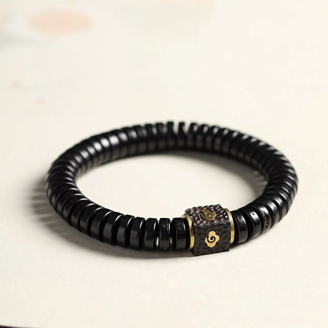 Coconut shell auspicious clouds bracelet with black beads and brass cloud charm, three-quarter view
