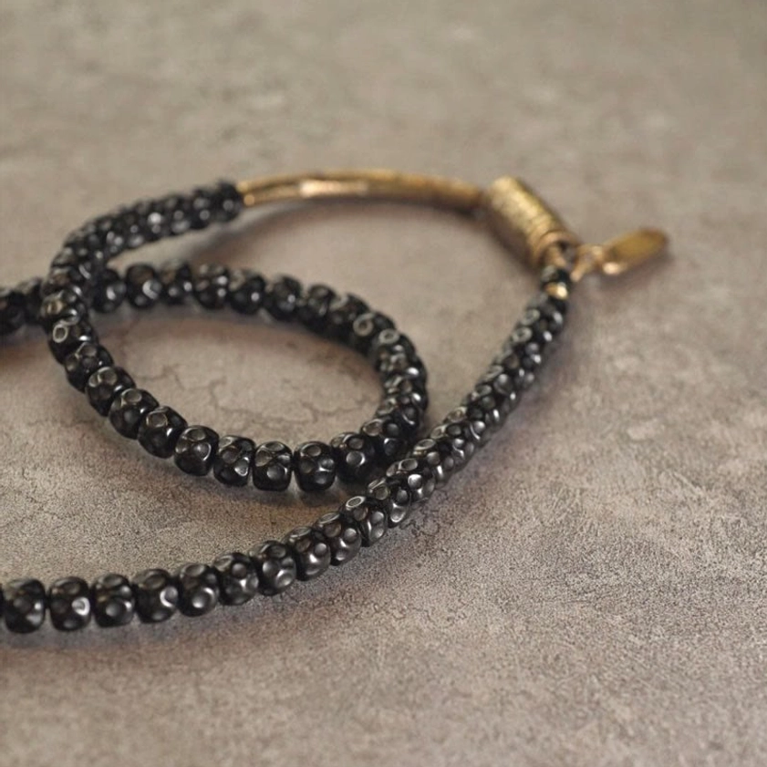 Unfolded coconut shell triple wrap bracelet with antique bronze hardware extended