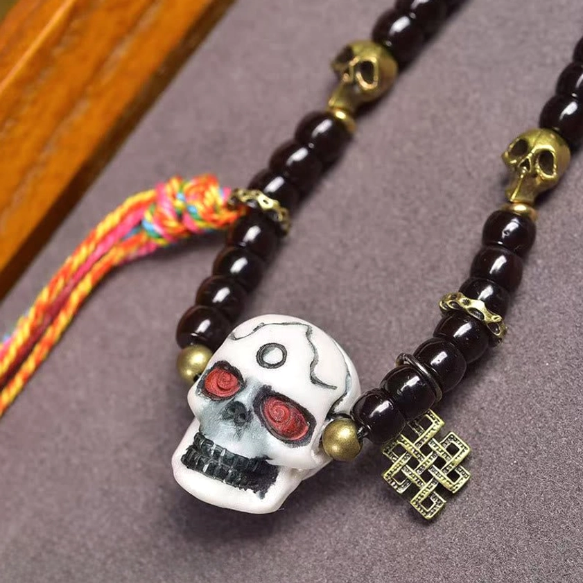 Side angle view of Buddhist prayer bracelet showing bead texture and metal accents