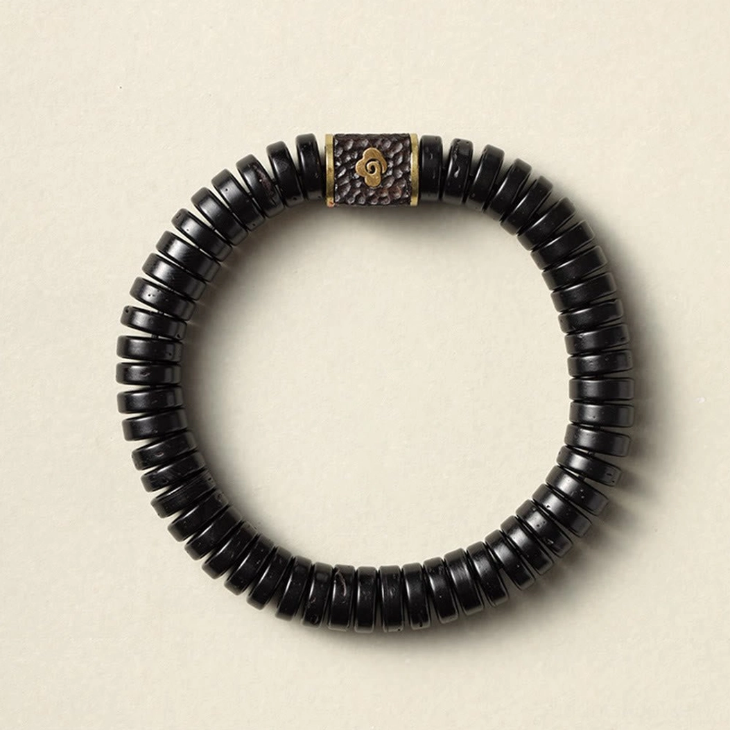 Handmade coconut shell beaded bracelet top-down view with central brass cloud spacer