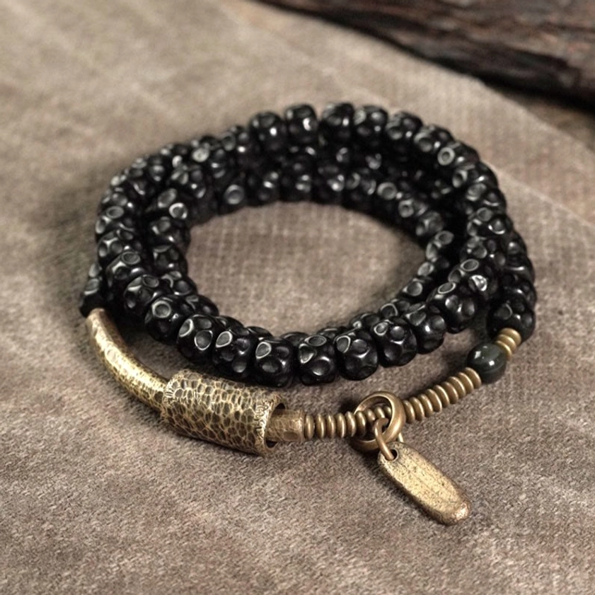 Natural coconut shell and antique brass triple wrap Buddhist bracelet flat lay overhead view