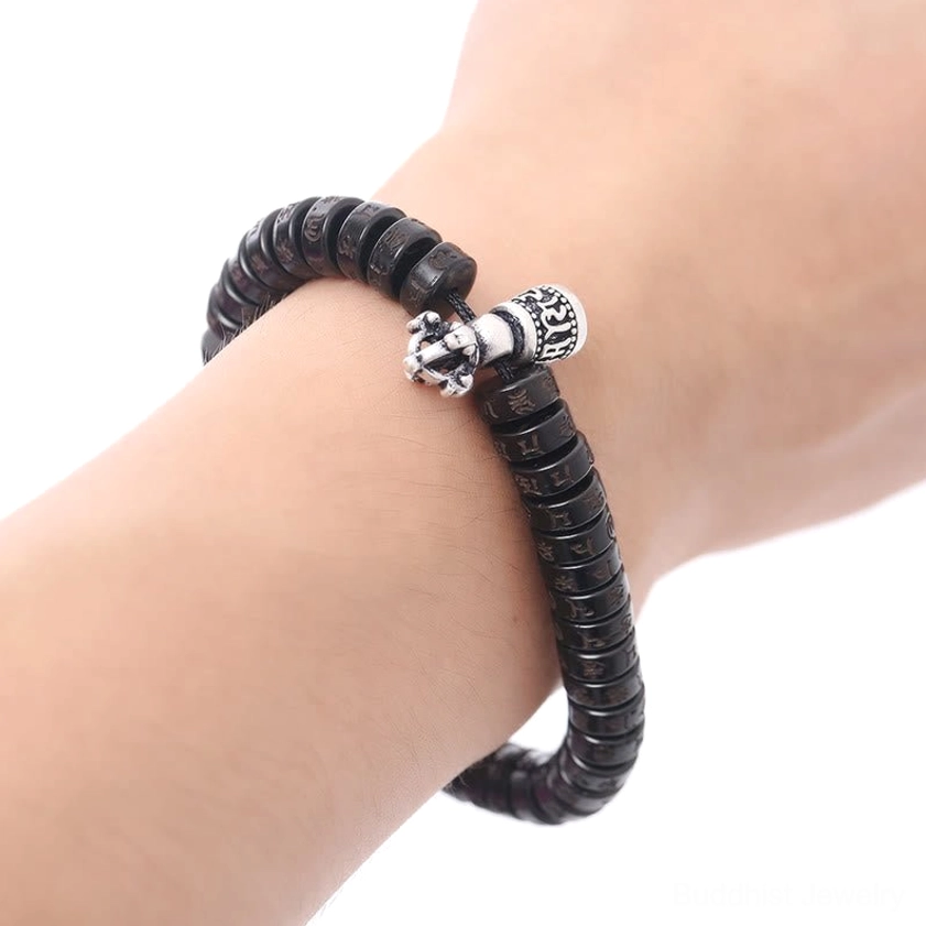 Om Mani Padme Hum coconut shell bracelet worn on wrist showing fit and silver charm decoration