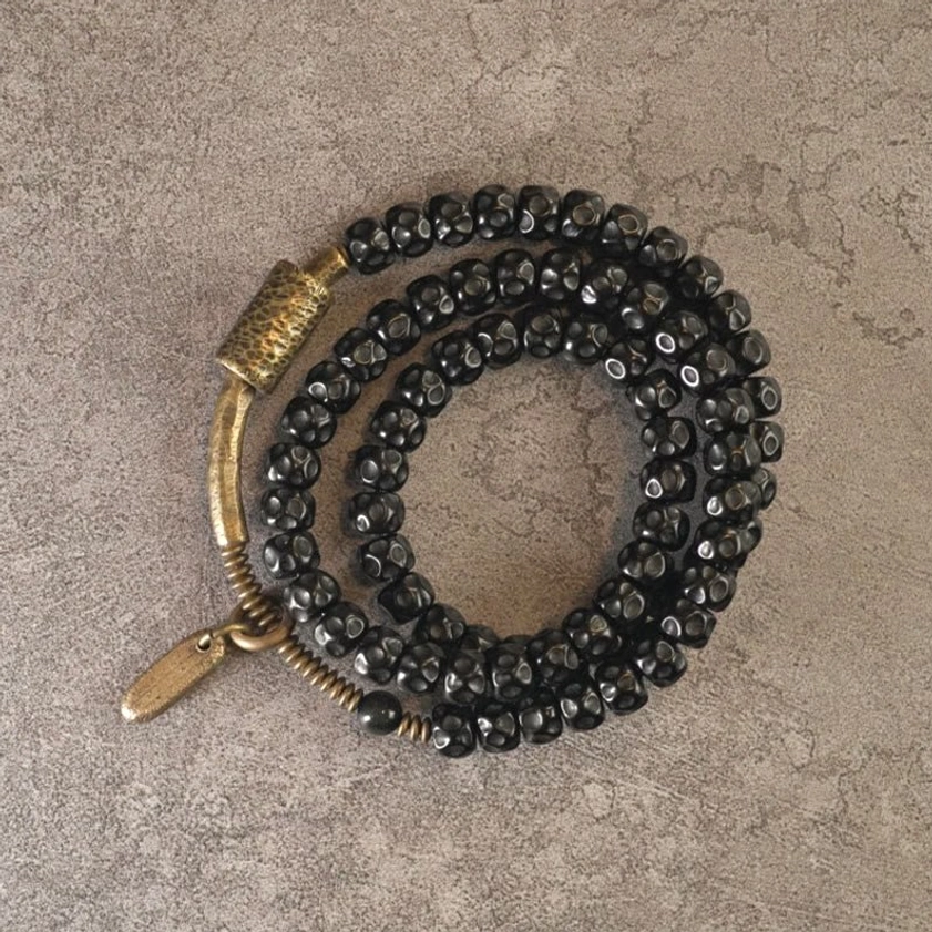 Triple wrap coconut shell bracelet with bronze toggle clasp flat lay