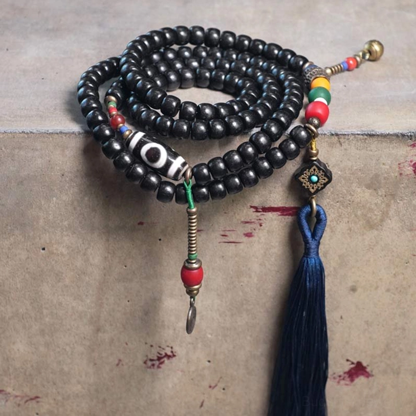 Coiled 108 bead mala set with ebony wood beads, navy blue tassel, and dzi bead - flat lay