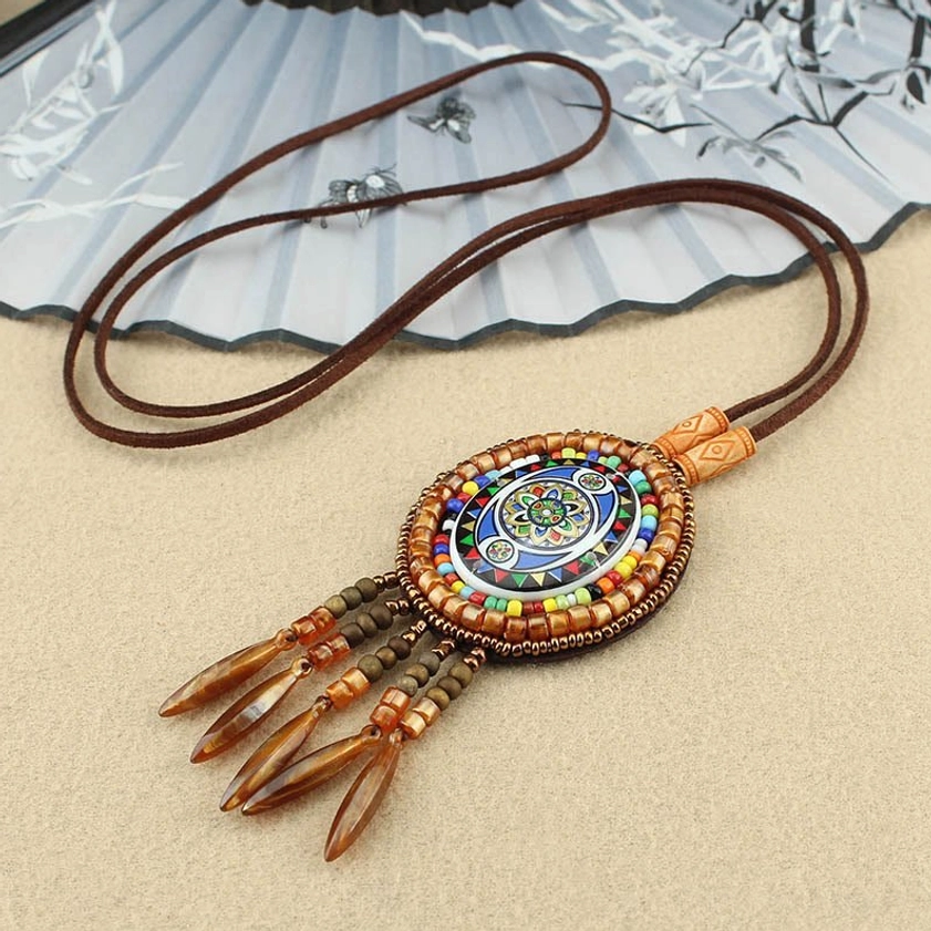 Colorful beads mandala pendant necklace with tassel strands and beige background, Buddhist meditation jewelry
