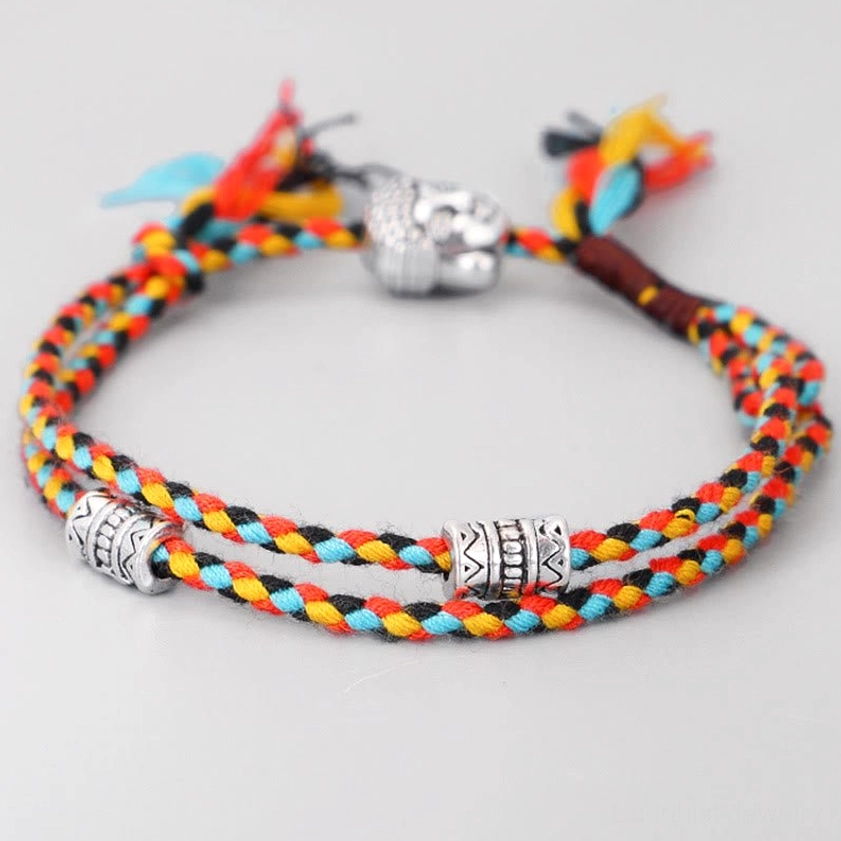 Colorful braided Buddha head string bracelet with rainbow cotton cord, front view on white background