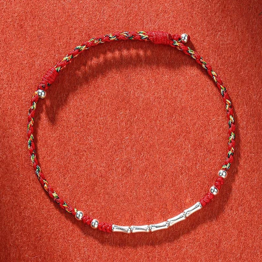 Colorful red braided protection bracelet displayed on terracotta background
