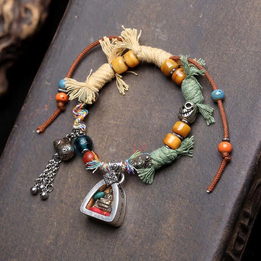 Colorful braided rope Amitabha Buddha bracelet with multi-color cord and Buddha shrine pendant, full view on wooden surface