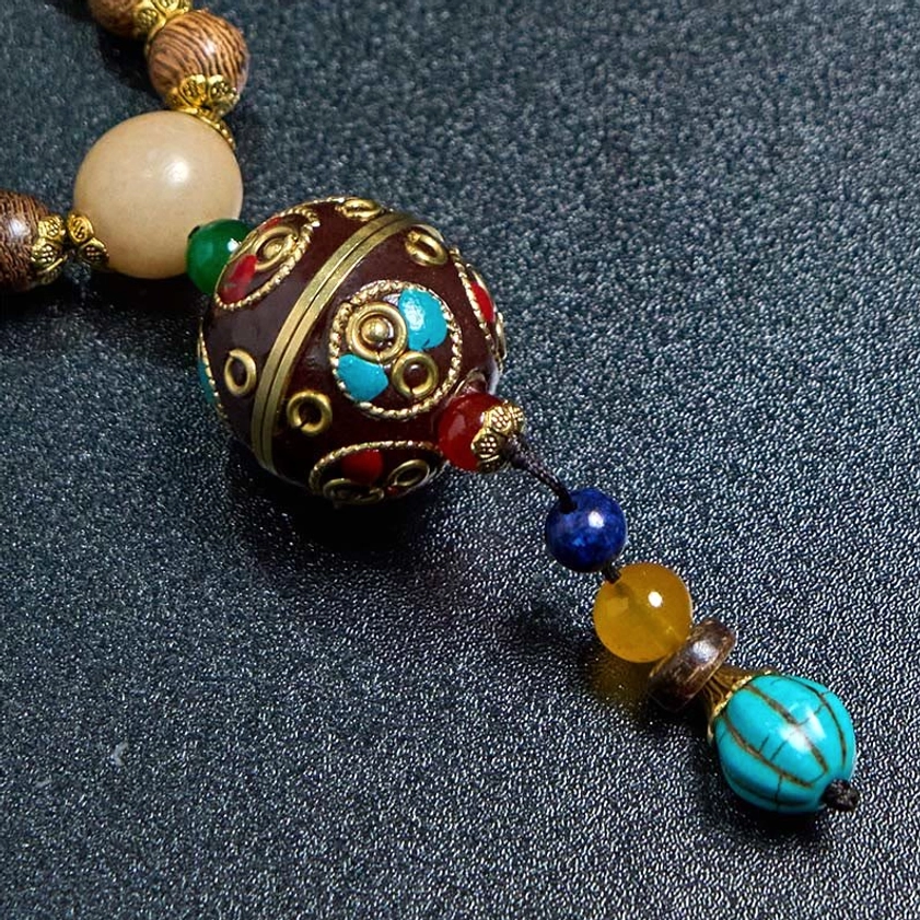Complete view of handcrafted Buddhist necklace with coconut shell, wood beads and traditional pendant