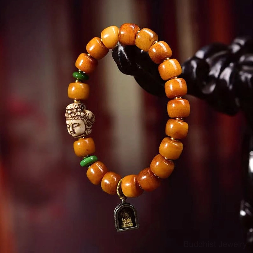Full circle camel bone Buddhist bracelet display featuring carved Buddha head, green jade spacers, hanging shrine pendant charm, and natural bone construction against blurred red background