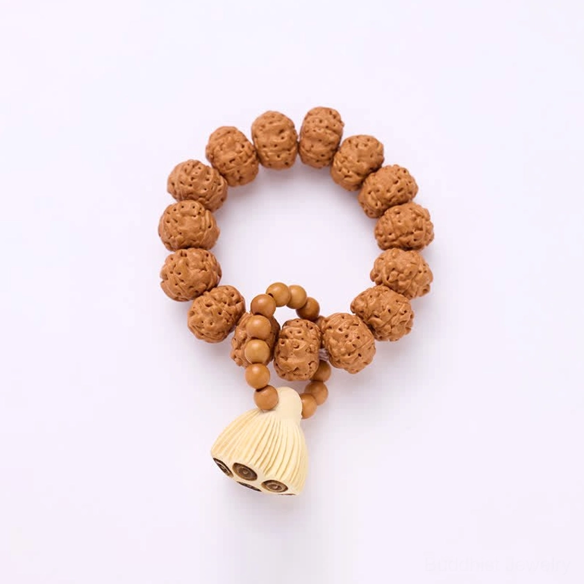 Circular vajra seed meditation bracelet with dangling lotus pod on soft pink background showing complete mala strand
