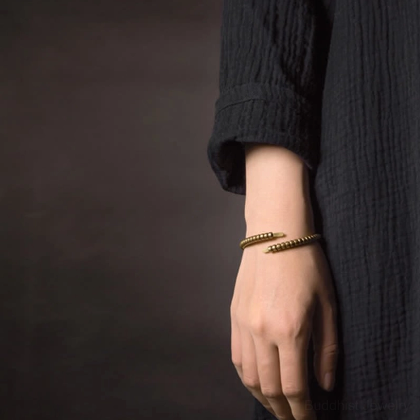 Stacked copper balance cuff bracelets worn on hand, dark linen clothing background, minimalist dual wear