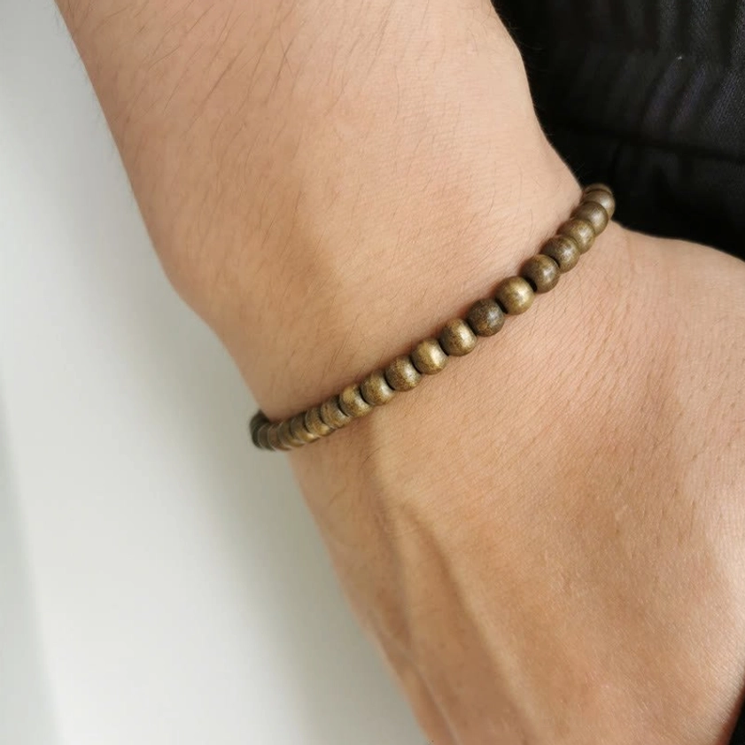 Copper brass bracelet worn on wrist, slim minimalist fit showing 5mm polished beads for spiritual grounding