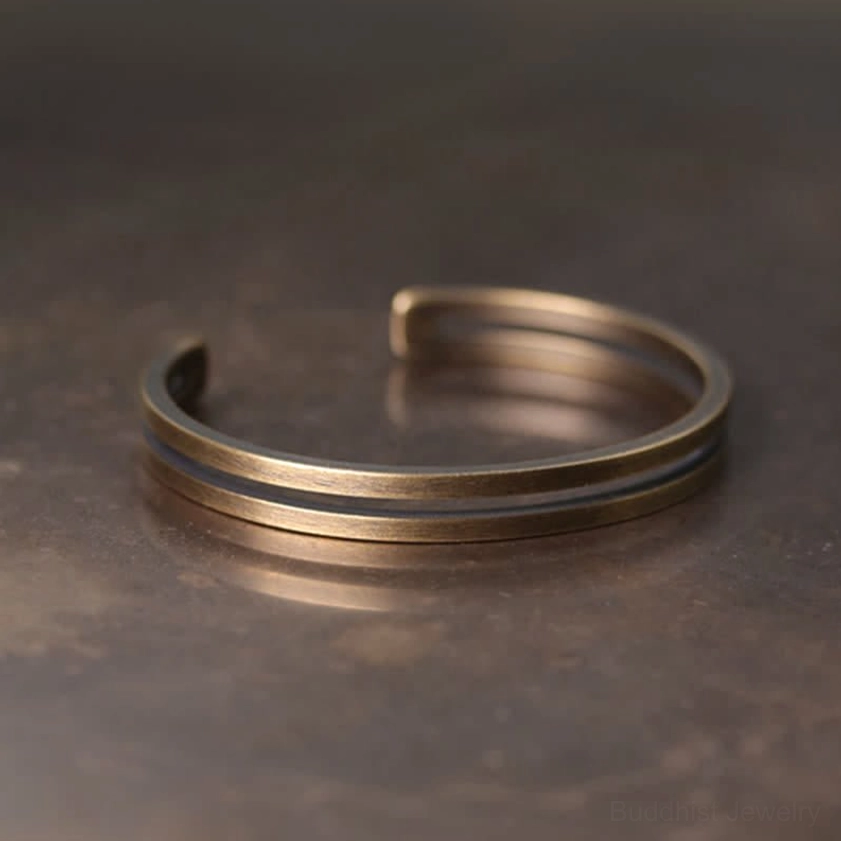 Close-up detail of handmade copper cuff bracelet showing warm matte bronze finish and texture