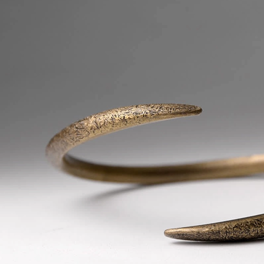 Close-up detail of copper cuff bracelet texture and matte finish with open adjustable mechanism