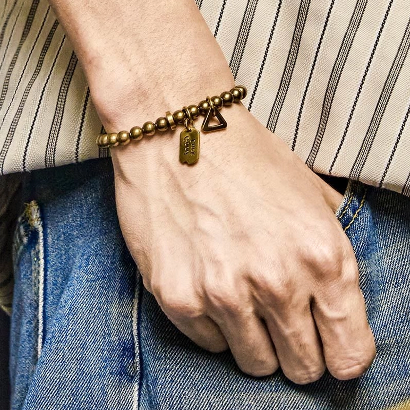 Copper brass Buddhist bracelet worn on wrist in casual lifestyle setting with natural accessories