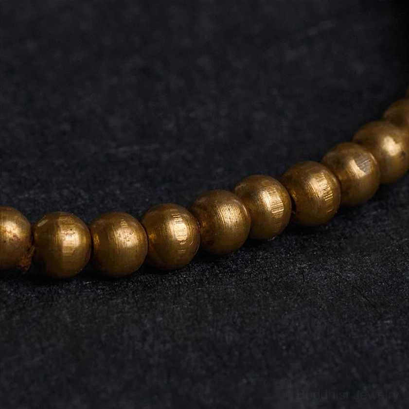 Close-up macro view of polished copper brass round beads showing metallic luster and smooth finish