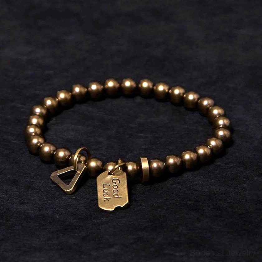 Copper brass prosperity bracelet side profile showing matte metal texture and branded pendant detail