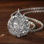Copper Buddha and demon relief pendant necklace, three-quarter left angle view showing intricate carved details and aged copper finish