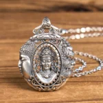 Handcrafted copper Buddha pendant necklace with dual-face carved design and intricate relief details, front view on wooden table