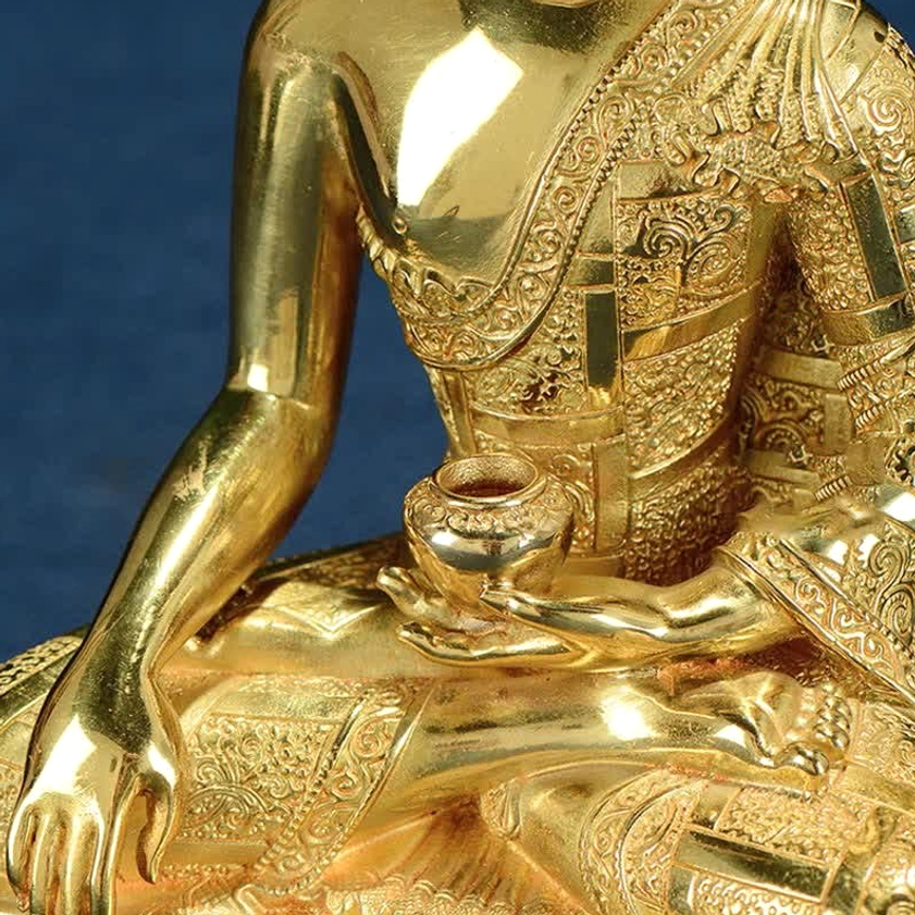 Copper Buddha Shakyamuni statue with golden patina and ceremonial base design