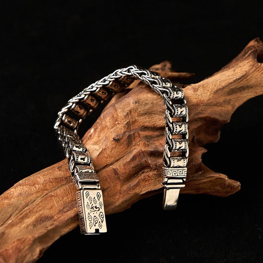Close-up vertical side angle of vintage copper Buddhist bracelet featuring engraved sacred motifs and structured chain
