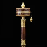 Small copper Buddhist prayer wheel with Om Mani Padme Hum mantra, front view with gold accents and hanging bell charm