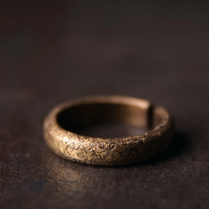 Single vintage copper Buddhist ring with warm bronze tone and full wrapped textured band, three-quarter view