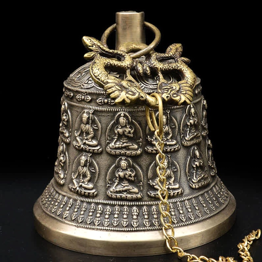Side close-up view of embossed Buddhist patterns and dragon finial on handmade copper chime bell