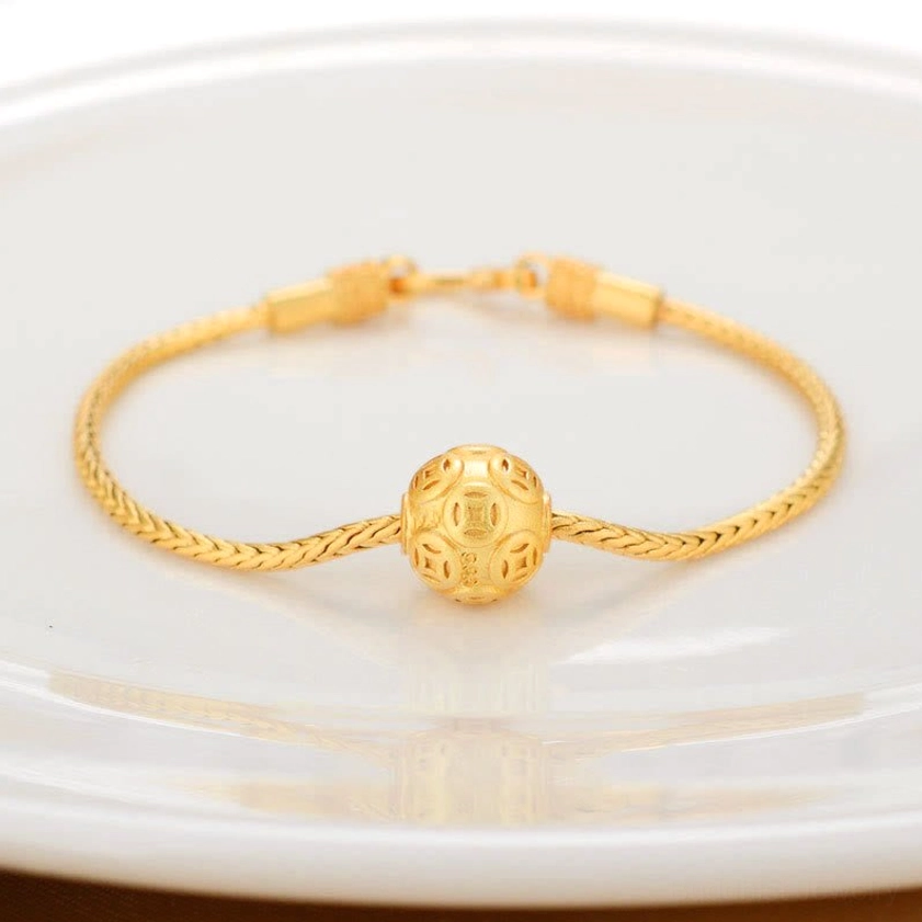 Buddhist bracelet with embossed copper coin charm on twisted gold chain
