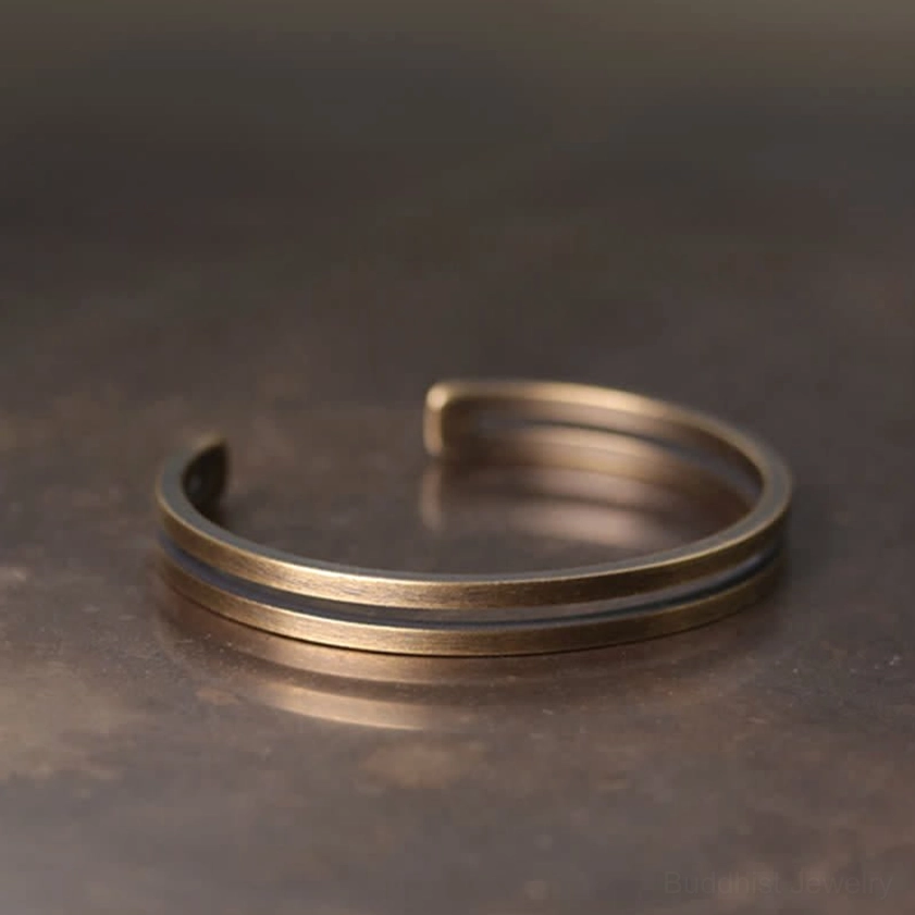 Front oblique view of dual parallel band copper cuff bracelet with smooth bronze metal texture